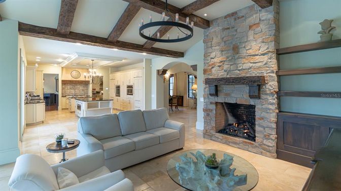 Chandelier, Dining room, Fireplace, Interior, Kitchen, Living room, Pendant Lights, Recessed Lighting, Stainless Steel Appliances, Stone Walls, Wooden Beams
