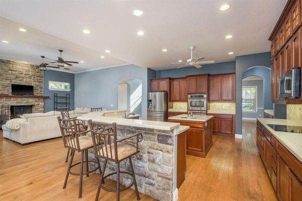 Dining room, Fireplace, Interior, Kitchen, Living room, Recessed Lighting, Stainless Steel Appliances, Stone Walls, Wood Texture Flooring