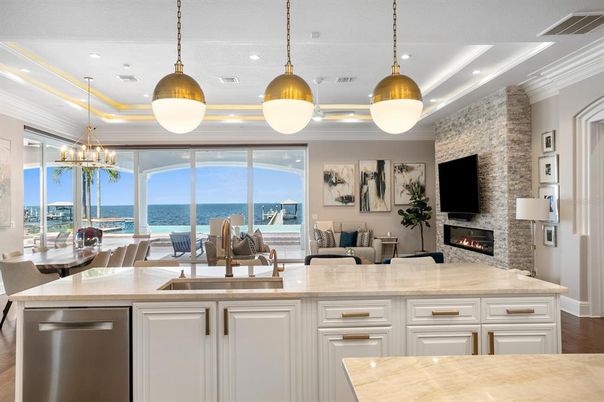 Dining room, Fireplace, Interior, Kitchen, Living room, Pendant Lights, Recessed Lighting, Stainless Steel Appliances, Stone Walls, Water, Wood Texture Flooring