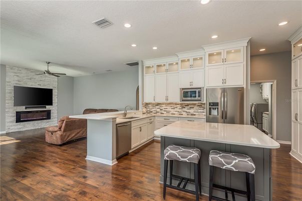 Fireplace, Interior, Kitchen, Living room, Recessed Lighting, Stainless Steel Appliances, Stone Walls, Wood Texture Flooring
