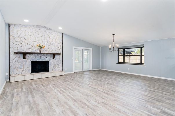 Chandelier, Empty room, Fireplace, Interior, Recessed Lighting, Stone Walls, Wood Texture Flooring