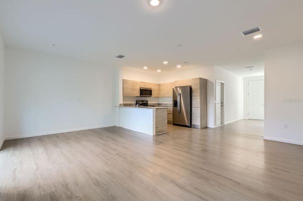 Empty room, Interior, Kitchen, Recessed Lighting, Stainless Steel Appliances, Wood Texture Flooring