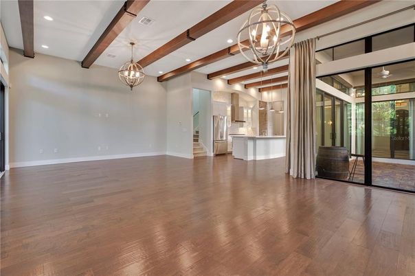 Chandelier, Empty room, Interior, Kitchen, Pendant Lights, Recessed Lighting, Stainless Steel Appliances, Wooden Beams, Wood Texture Flooring