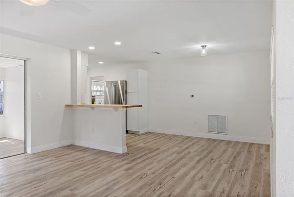 Empty room, Interior, Kitchen, Recessed Lighting, Stainless Steel Appliances, Wood Texture Flooring