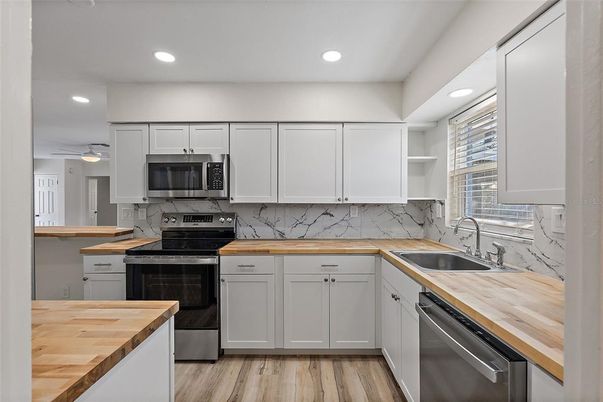 Interior, Kitchen, Marble Walls, Recessed Lighting, Stainless Steel Appliances, Wood Texture Flooring