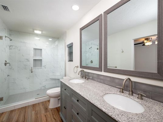 Bathroom, Dual Sink Vanities, Glass Shower, Interior, Marble Walls, Recessed Lighting, Wood Texture Flooring