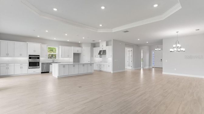 Chandelier, Empty room, Interior, Kitchen, Pendant Lights, Recessed Lighting, Stainless Steel Appliances, Wood Texture Flooring