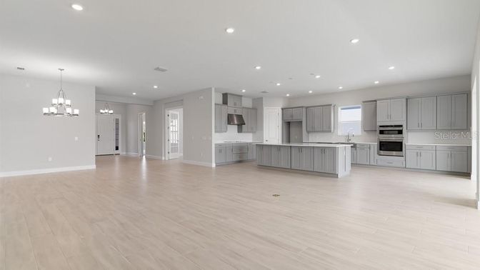Chandelier, Empty room, Interior, Kitchen, Pendant Lights, Recessed Lighting, Stainless Steel Appliances, Wood Texture Flooring