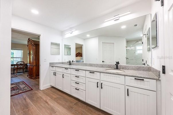 Bathroom, Dual Sink Vanities, Interior, Marble Walls, Recessed Lighting, Wood Texture Flooring