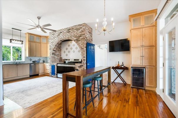 Chandelier, Fireplace, Interior, Kitchen, Pendant Lights, Stainless Steel Appliances, Stone Walls, Wood Texture Flooring
