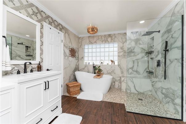 Bathroom, Dual Sink Vanities, Free Standing Baths, Glass Shower, Interior, Marble Walls, Recessed Lighting, Wood Texture Flooring