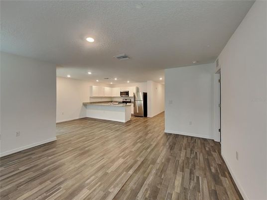 Empty room, Interior, Kitchen, Recessed Lighting, Stainless Steel Appliances, Wood Texture Flooring