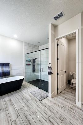 Bathroom, Free Standing Baths, Glass Shower, Interior, Recessed Lighting, Wood Texture Flooring