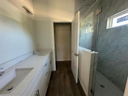 Bathroom, Dual Sink Vanities, Glass Shower, Interior, Marble Walls, Wood Texture Flooring