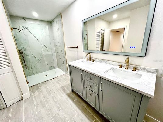 Bathroom, Dual Sink Vanities, Glass Shower, Interior, Marble Walls, Recessed Lighting, Wood Texture Flooring