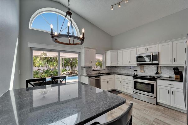 Chandelier, Dining room, Interior, Kitchen, Pendant Lights, Stainless Steel Appliances, Wood Texture Flooring