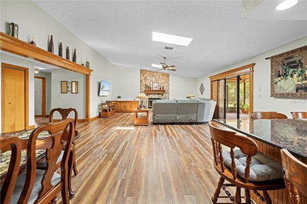 Dining room, Fireplace, Interior, Living room, Recessed Lighting, Stone Walls, Wood Texture Flooring