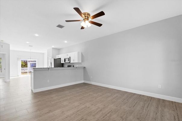 Empty room, Interior, Kitchen, Recessed Lighting, Stainless Steel Appliances, Wood Texture Flooring