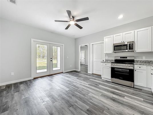 Empty room, Interior, Kitchen, Recessed Lighting, Stainless Steel Appliances, Wood Texture Flooring
