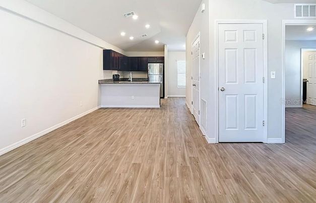 Empty room, Interior, Kitchen, Recessed Lighting, Stainless Steel Appliances, Wood Texture Flooring