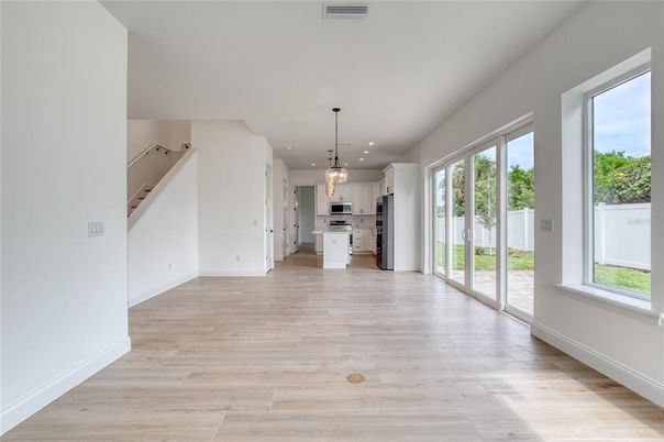 Empty room, Interior, Kitchen, Pendant Lights, Recessed Lighting, Stainless Steel Appliances, Wood Texture Flooring