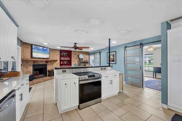 Fireplace, Interior, Kitchen, Recessed Lighting, Stainless Steel Appliances, Stone Walls