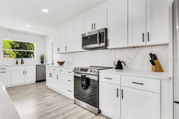 Interior, Kitchen, Marble Walls, Recessed Lighting, Stainless Steel Appliances, Wood Texture Flooring