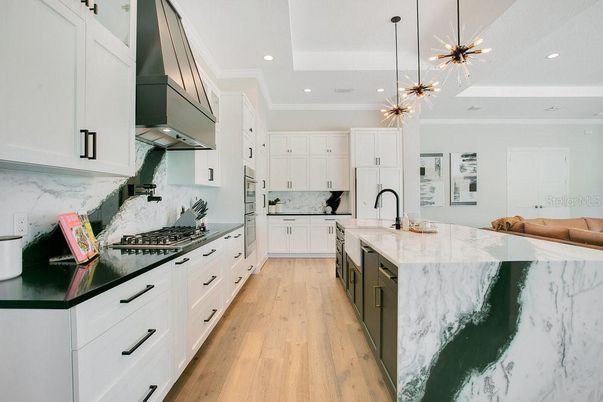 Interior, Kitchen, Marble Walls, Pendant Lights, Recessed Lighting, Stainless Steel Appliances, Wood Texture Flooring