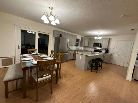 Chandelier, Dining room, Interior, Kitchen, Pendant Lights, Stainless Steel Appliances, Wood Texture Flooring