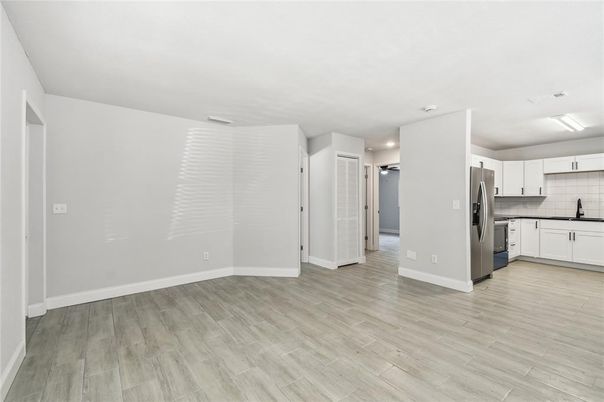 Empty room, Interior, Kitchen, Recessed Lighting, Stainless Steel Appliances, Wood Texture Flooring