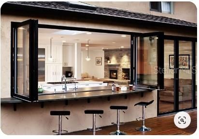 Fireplace, Interior, Kitchen, Pendant Lights, Recessed Lighting, Stainless Steel Appliances, Stone Walls, Wood Texture Flooring