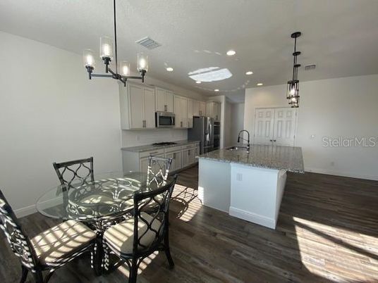 Chandelier, Dining room, Interior, Kitchen, Pendant Lights, Recessed Lighting, Stainless Steel Appliances, Wood Texture Flooring