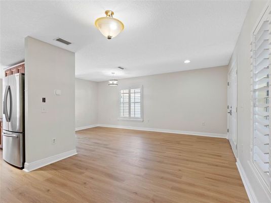 Empty room, Interior, Kitchen, Recessed Lighting, Stainless Steel Appliances, Wood Texture Flooring