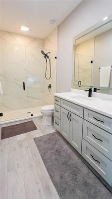 Bathroom, Dual Sink Vanities, Glass Shower, Interior, Marble Walls, Recessed Lighting