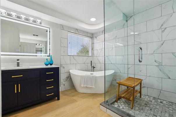 Bathroom, Dual Sink Vanities, Free Standing Baths, Glass Shower, Interior, Marble Walls, Recessed Lighting, Wood Texture Flooring