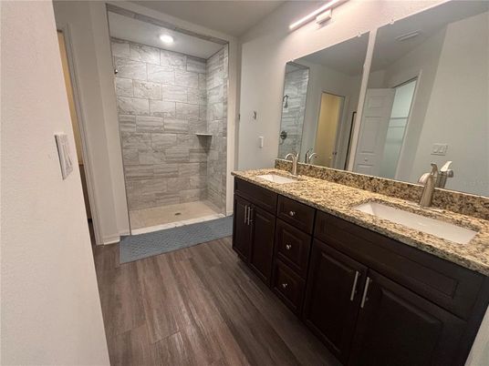 Bathroom, Dual Sink Vanities, Interior, Recessed Lighting, Stone Walls, Wood Texture Flooring