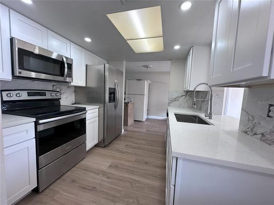 Interior, Kitchen, Marble Walls, Recessed Lighting, Stainless Steel Appliances, Wood Texture Flooring
