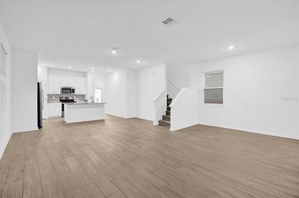 Empty room, Interior, Kitchen, Recessed Lighting, Stainless Steel Appliances, Wood Texture Flooring