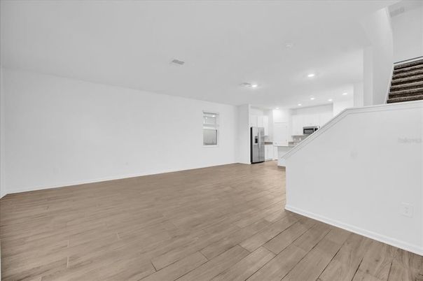Empty room, Interior, Kitchen, Recessed Lighting, Stainless Steel Appliances, Wood Texture Flooring