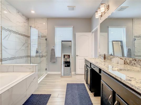 Bathroom, Dual Sink Vanities, Glass Shower, Interior, Marble Walls, Recessed Lighting, Wood Texture Flooring