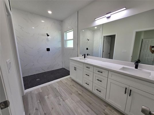 Bathroom, Dual Sink Vanities, Interior, Marble Walls, Recessed Lighting, Wood Texture Flooring
