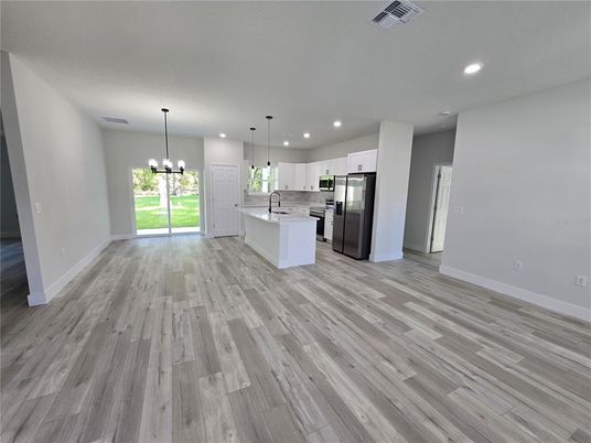 Chandelier, Empty room, Interior, Kitchen, Pendant Lights, Recessed Lighting, Stainless Steel Appliances, Wood Texture Flooring