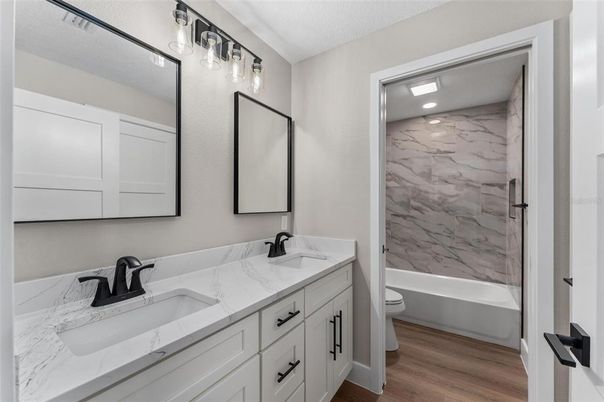 Bathroom, Dual Sink Vanities, Interior, Marble Walls, Recessed Lighting, Wood Texture Flooring