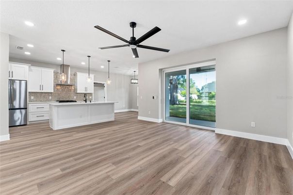 Empty room, Interior, Kitchen, Pendant Lights, Recessed Lighting, Stainless Steel Appliances, Wood Texture Flooring