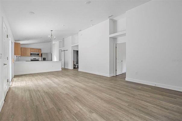 Chandelier, Empty room, Interior, Kitchen, Recessed Lighting, Stainless Steel Appliances, Wood Texture Flooring