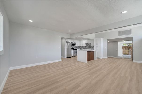 Empty room, Interior, Kitchen, Recessed Lighting, Stainless Steel Appliances, Wood Texture Flooring