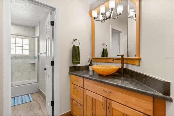 Bathroom, Chandelier, Glass Shower, Interior, Tile Countertops, Wood Texture Flooring