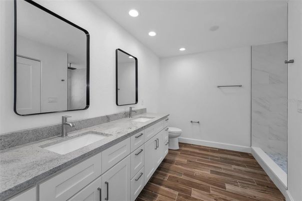 Bathroom, Dual Sink Vanities, Interior, Marble Walls, Recessed Lighting, Wood Texture Flooring