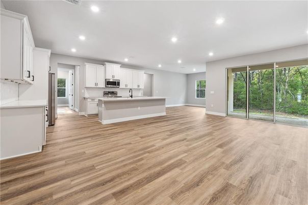 Empty room, Interior, Kitchen, Recessed Lighting, Stainless Steel Appliances, Wood Texture Flooring
