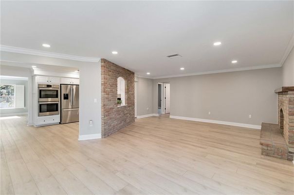 Empty room, Fireplace, Interior, Kitchen, Recessed Lighting, Stainless Steel Appliances, Stone Walls, Wood Texture Flooring